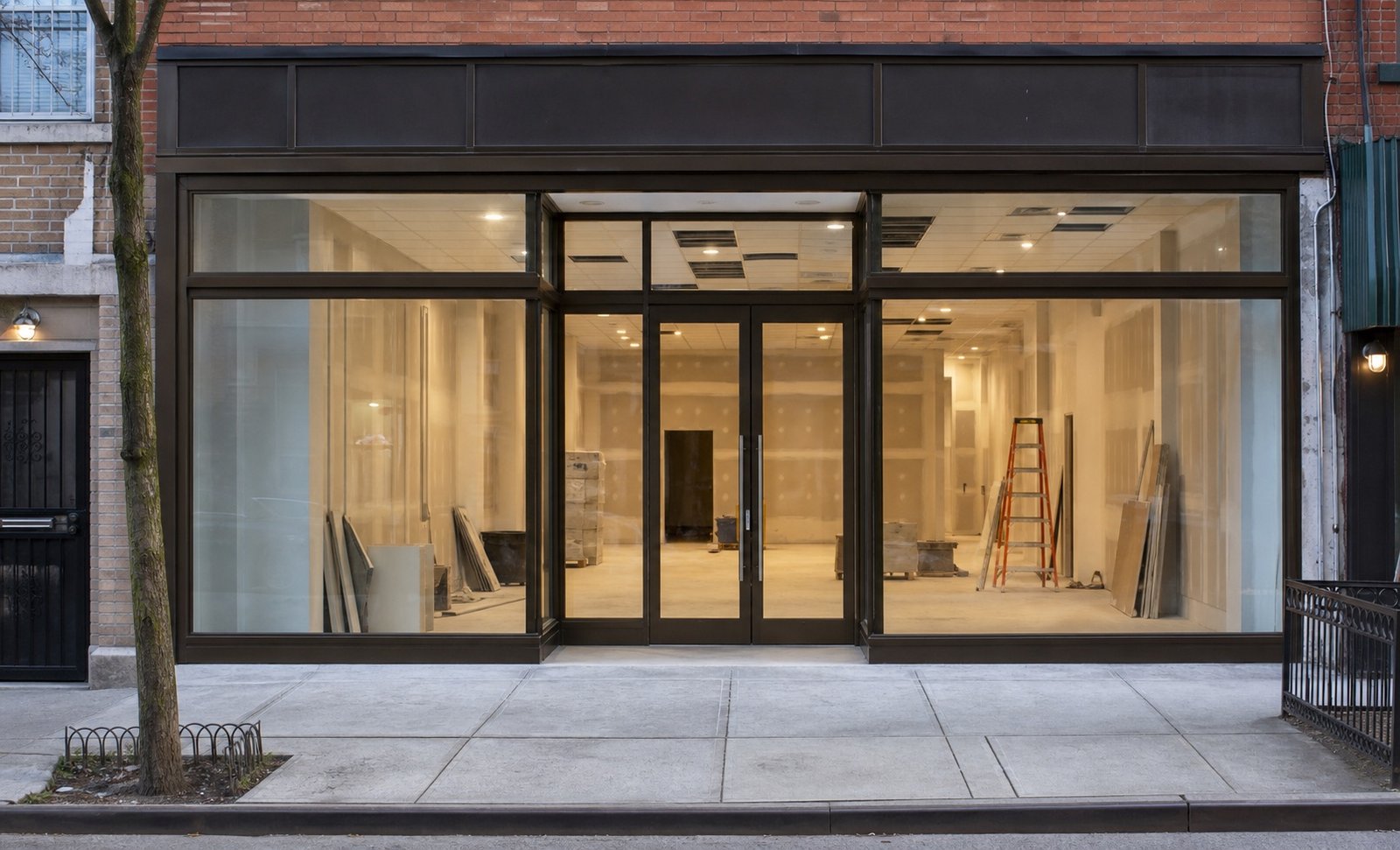 Queens retail storefront renovation with new glazing and an interior build-out in progress